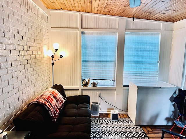 living room featuring brick wall and wooden ceiling