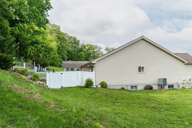 view of side of property featuring a yard and central air condition unit