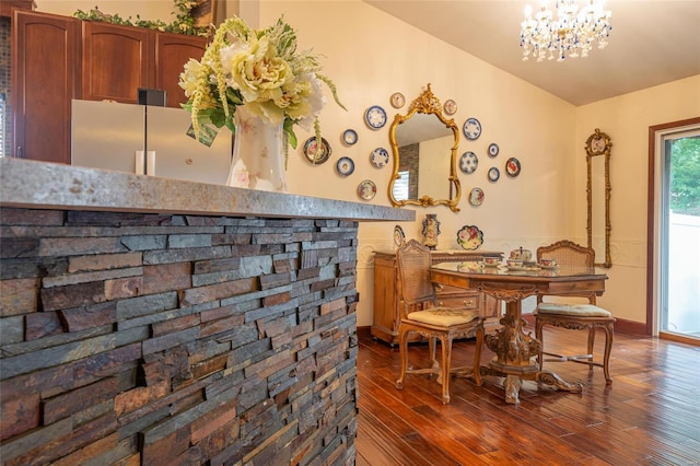 dining area with dark hardwood / wood-style floors and a chandelier