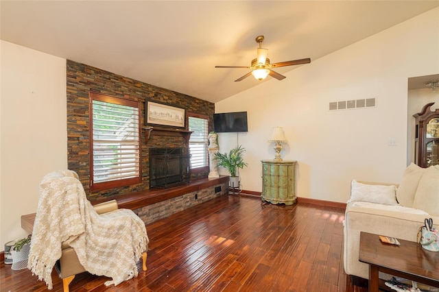 living room featuring a stone fireplace, vaulted ceiling, ceiling fan, and hardwood / wood-style flooring