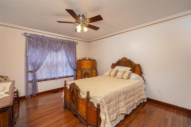 bedroom featuring ornamental molding, dark wood-type flooring, and ceiling fan