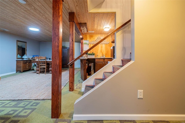 staircase featuring carpet flooring and wooden ceiling