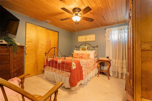 bedroom featuring ceiling fan, a closet, light carpet, and wooden ceiling