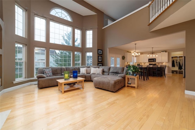 living room with a notable chandelier and light hardwood / wood-style floors