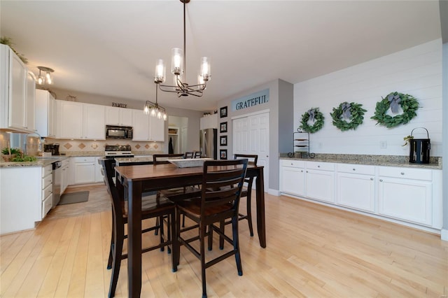 dining space featuring a chandelier and light wood-type flooring