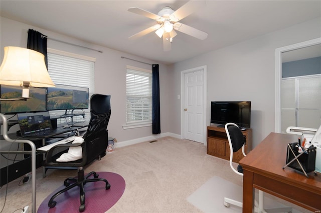 carpeted office space with ceiling fan