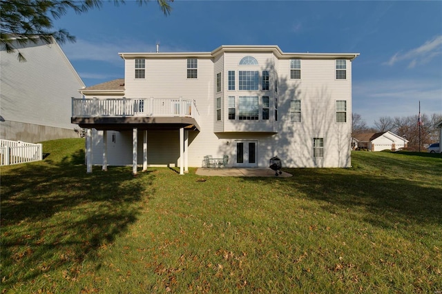 back of house with french doors, a deck, and a lawn