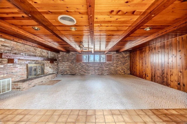 unfurnished living room with brick wall, a fireplace, light carpet, wooden ceiling, and beam ceiling