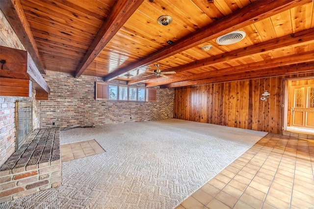 unfurnished living room featuring wooden ceiling, light tile patterned floors, wooden walls, beamed ceiling, and brick wall