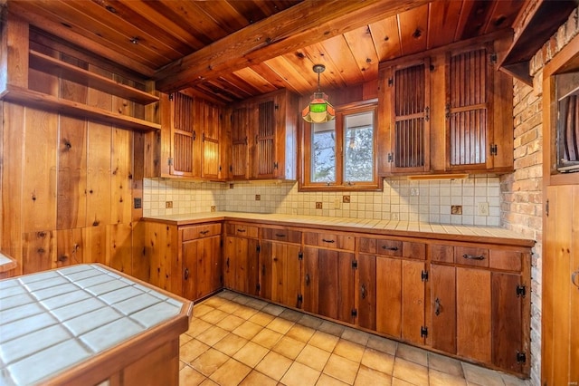 kitchen with pendant lighting, backsplash, and tile counters