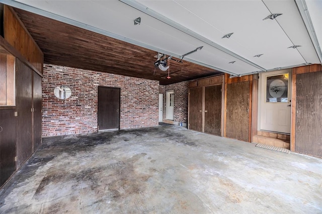 garage with a garage door opener and wooden walls