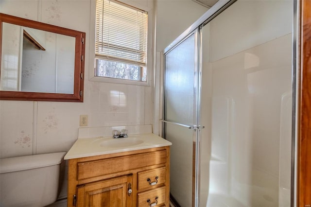 bathroom featuring vanity, toilet, and a shower with shower door