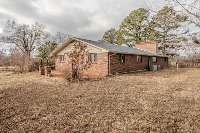 view of side of home with central AC unit, a patio area, and a lawn