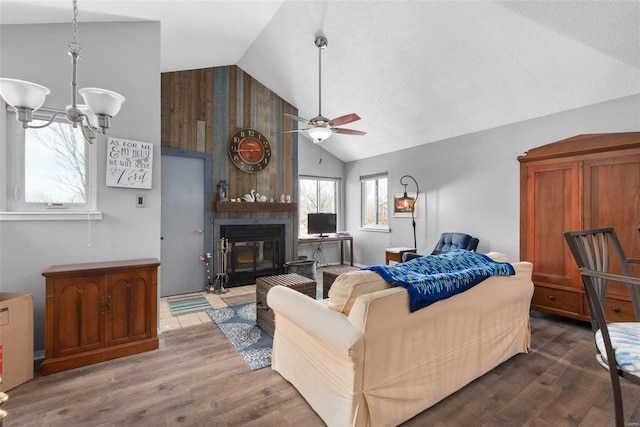 living room featuring ceiling fan with notable chandelier, lofted ceiling, a large fireplace, and hardwood / wood-style floors