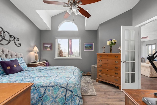 bedroom featuring ceiling fan, light hardwood / wood-style floors, and vaulted ceiling