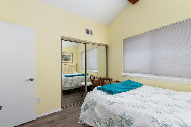 bedroom featuring lofted ceiling with beams, dark wood-type flooring, and a closet