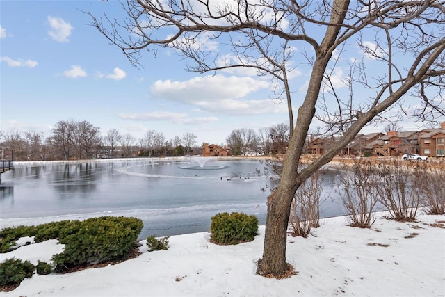 yard layered in snow featuring a water view