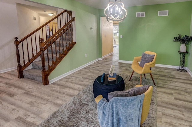 living area with wood-type flooring and an inviting chandelier