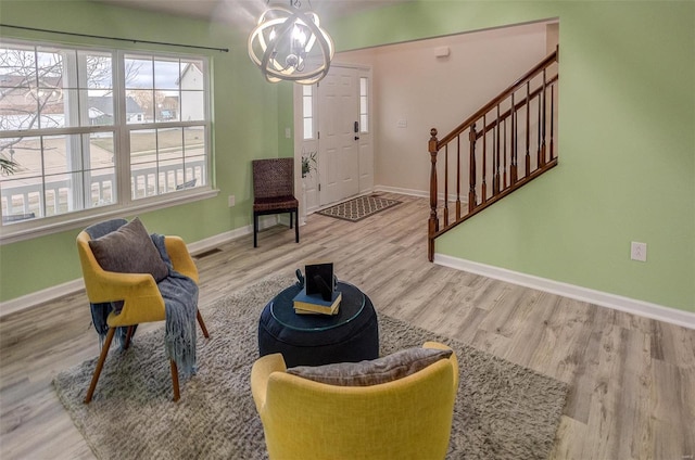 living area with an inviting chandelier and hardwood / wood-style floors