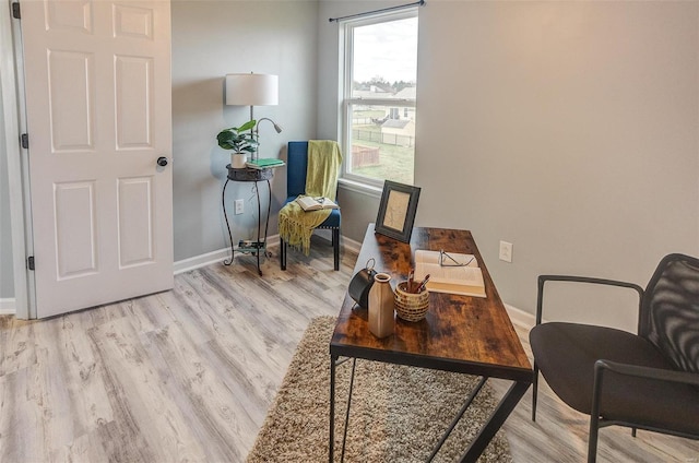 home office with light hardwood / wood-style floors