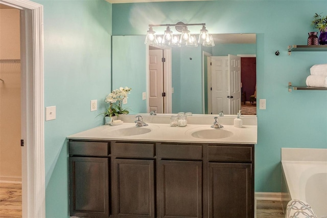 bathroom with vanity, a tub, and wood-type flooring