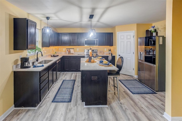 kitchen with hanging light fixtures, sink, a kitchen breakfast bar, and a center island