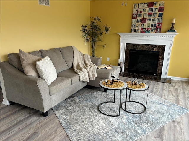 living room with wood-type flooring and a fireplace