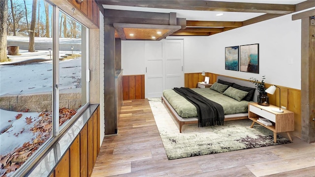 bedroom featuring access to outside, wooden walls, and light wood-type flooring