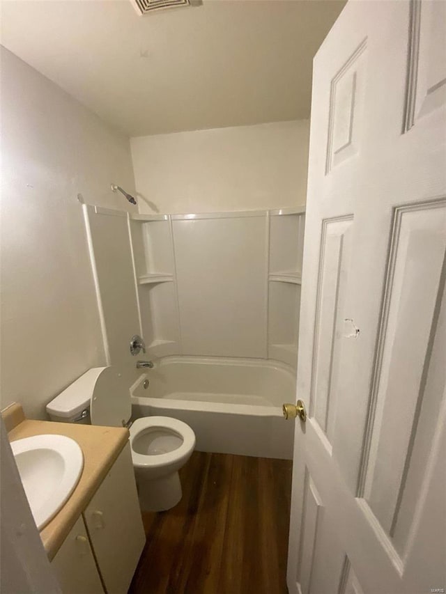 full bathroom featuring hardwood / wood-style flooring, vanity,  shower combination, and toilet