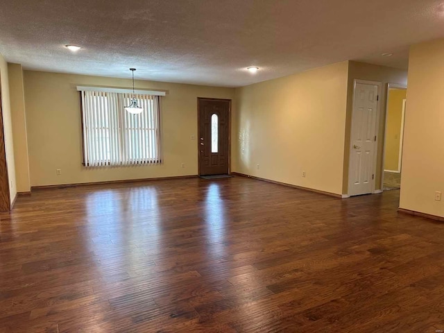 unfurnished room with dark hardwood / wood-style floors and a textured ceiling