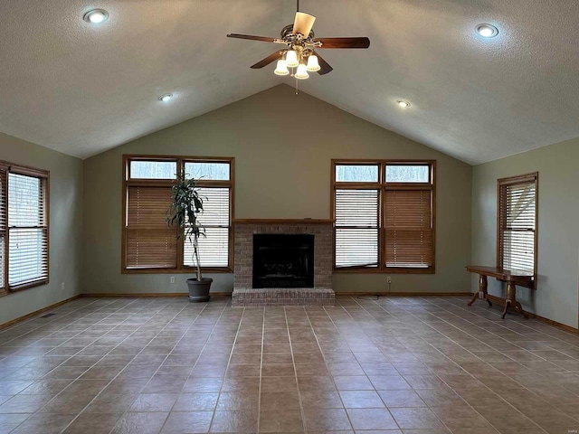 unfurnished living room featuring lofted ceiling, a wealth of natural light, a fireplace, and a textured ceiling