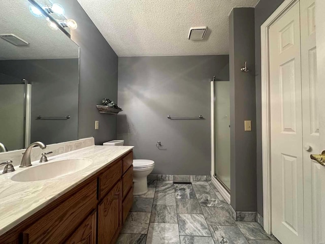 bathroom with vanity, toilet, an enclosed shower, and a textured ceiling