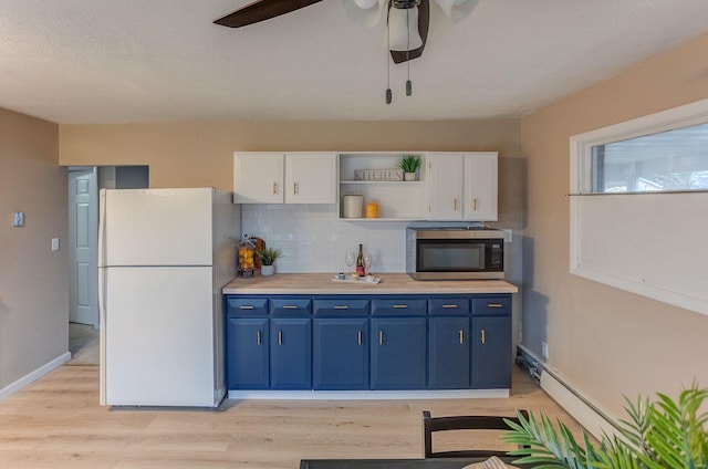 kitchen with blue cabinetry, decorative backsplash, white fridge, and white cabinets