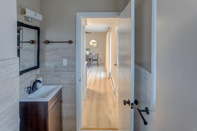 bathroom with vanity, wood-type flooring, and tile walls