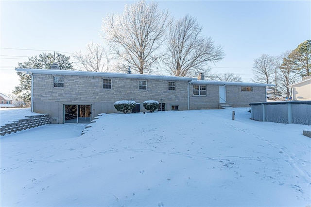 view of snow covered rear of property