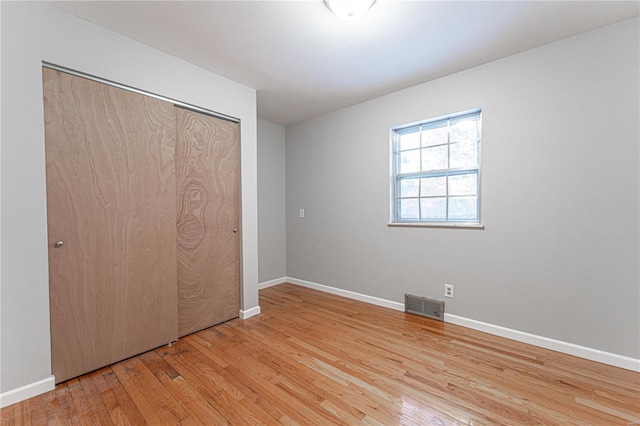 unfurnished bedroom featuring light hardwood / wood-style floors and a closet