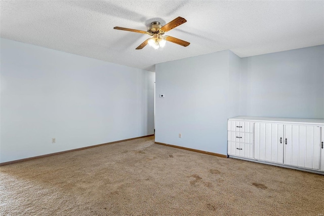 carpeted spare room with ceiling fan and a textured ceiling