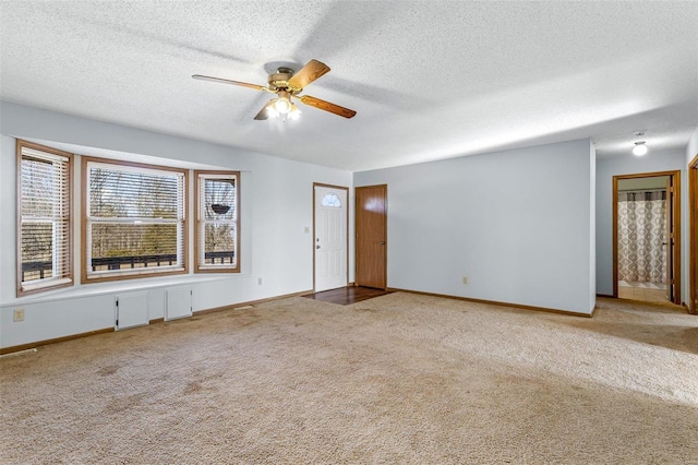 carpeted spare room with ceiling fan and a textured ceiling