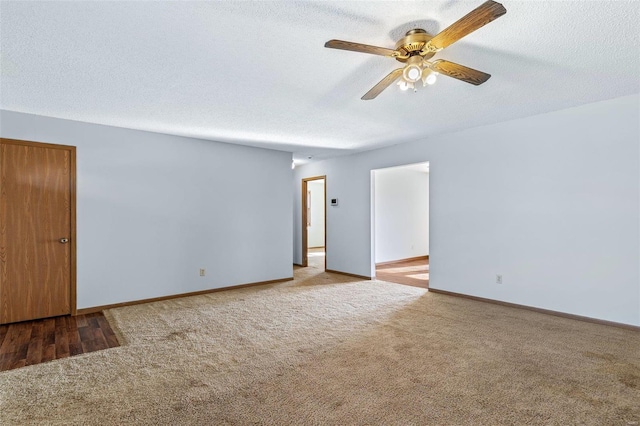 empty room featuring ceiling fan, light carpet, and a textured ceiling