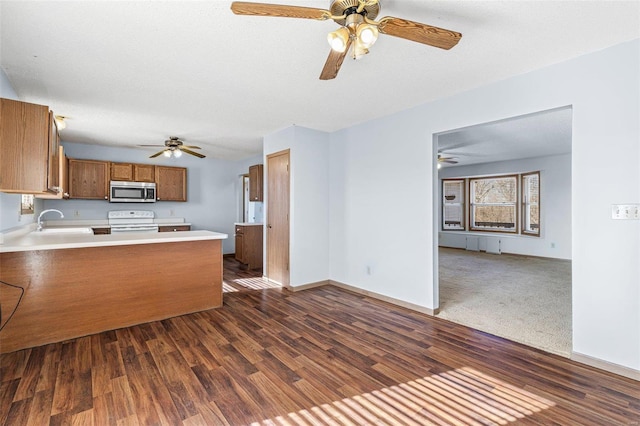 kitchen with dark wood-type flooring, sink, a textured ceiling, electric range, and kitchen peninsula