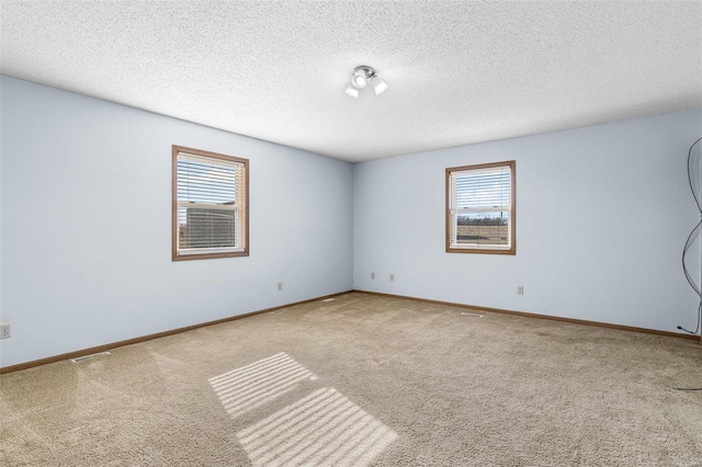 spare room featuring carpet and a textured ceiling