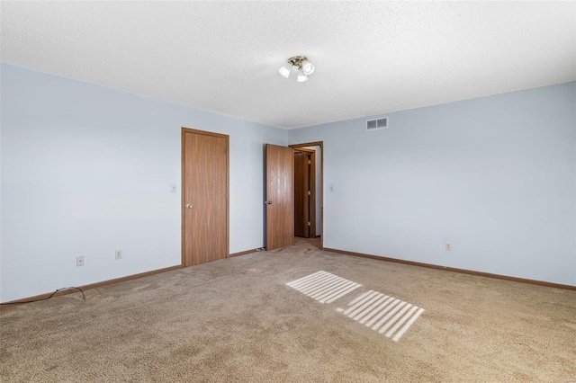 carpeted spare room with a textured ceiling