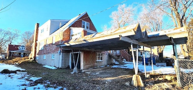 view of snowy exterior with a carport