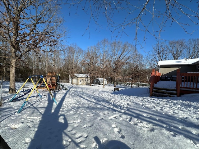 yard covered in snow featuring a playground