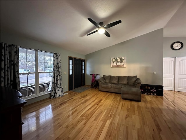 living room with lofted ceiling, ceiling fan, and wood finished floors