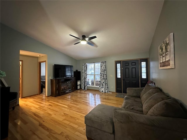 living room with vaulted ceiling, a ceiling fan, and light wood-style floors