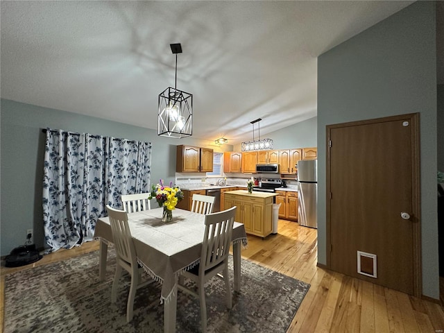 dining room with lofted ceiling and light wood finished floors