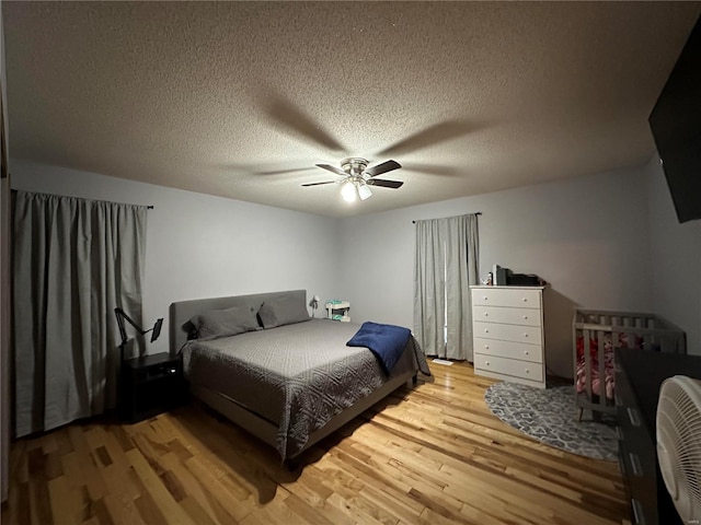 bedroom featuring a textured ceiling, wood finished floors, and a ceiling fan