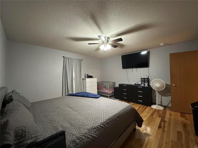 bedroom featuring a textured ceiling, light wood-style flooring, and a ceiling fan