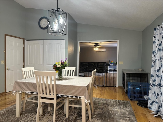 dining space featuring lofted ceiling, wood finished floors, and a ceiling fan